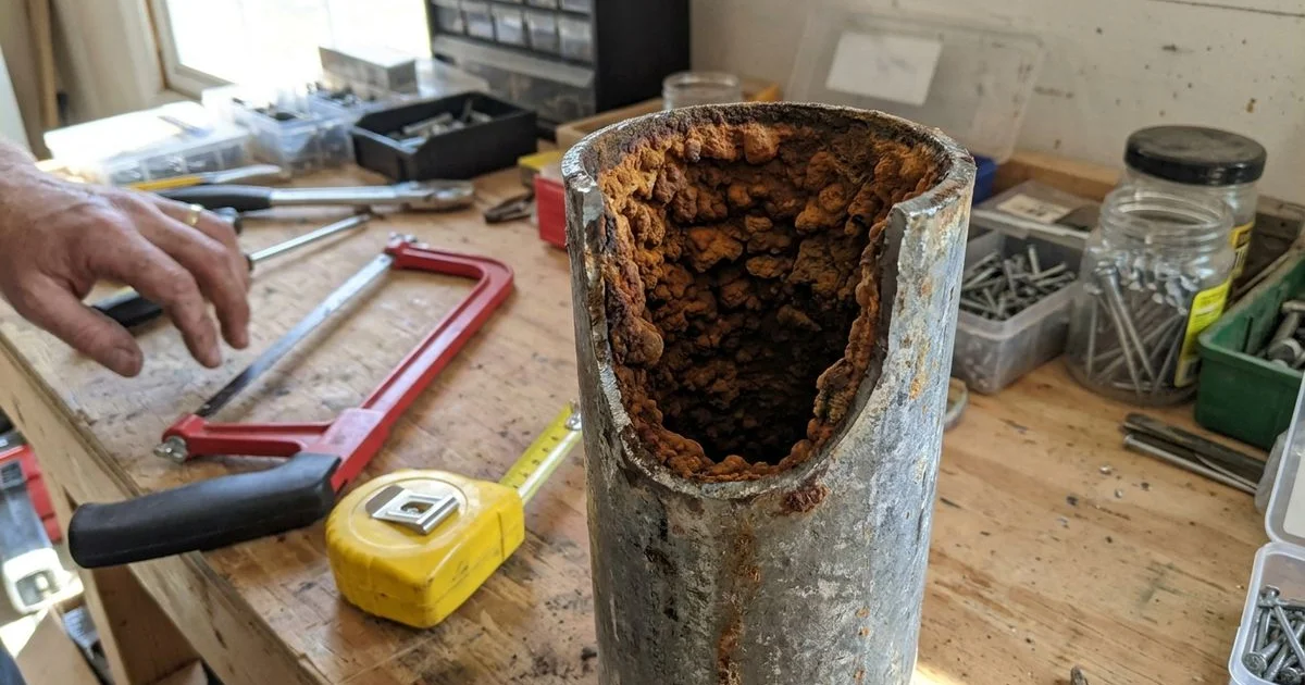 Cut section of corroded galvanized pipe showing tuberculation narrowing the inside