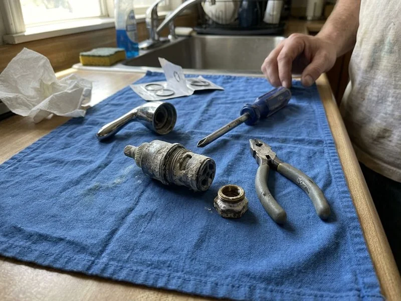 Disassembled faucet cartridge crusted with white mineral scale