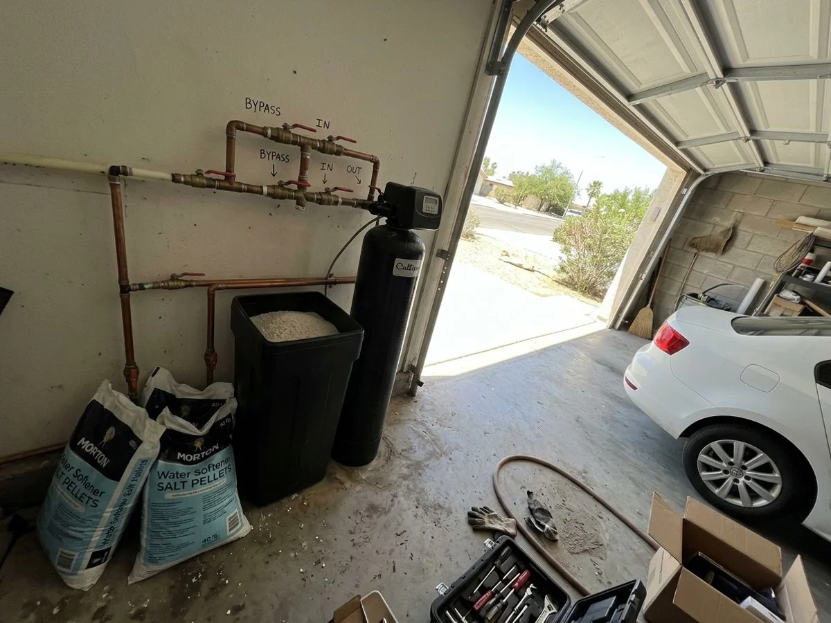 Whole-home water softener and brine tank installed beside the main line in an El Centro garage